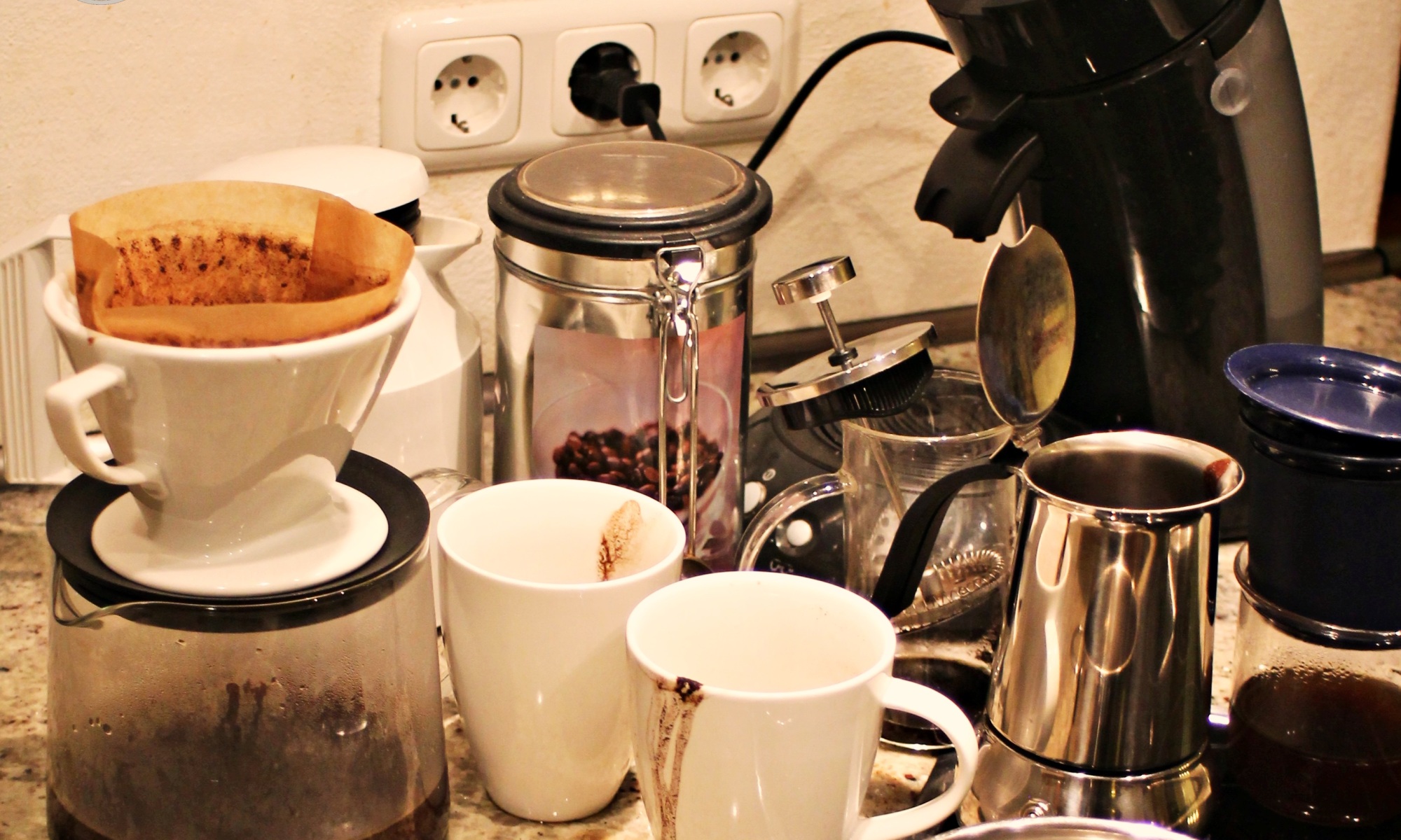 Das Bild zeigt die Ansammlung einiger Kaffeezubereitungsgeräte aus Glitzers Versuchsreihe. Alles in Allem ziemlich "benutzt", d.h. eingesaut.