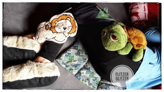 Umhüllt von Körnerkissen verschiedenster Art, liegt ein junges Mädchen gemütlich im Bett.