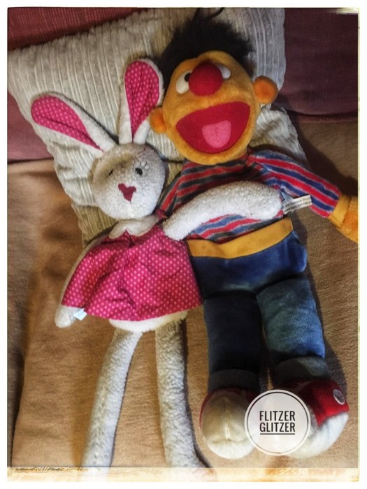 Kirschkernkissenmädchen Hanna im pinken Pünktchenkleid und Wärmflaschenernie, wie man ihn aus der Sesamstraße kennt.