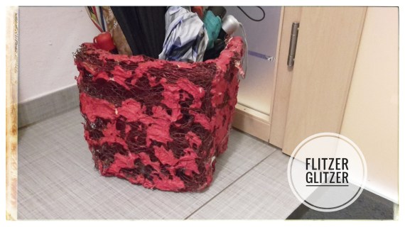 roter Übertopf aus Drahtgeflecht.