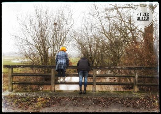 Flitzerglitzer hängen und stehen auf dem maroden Geländer einer in die Jahre gekommenen Brücke.