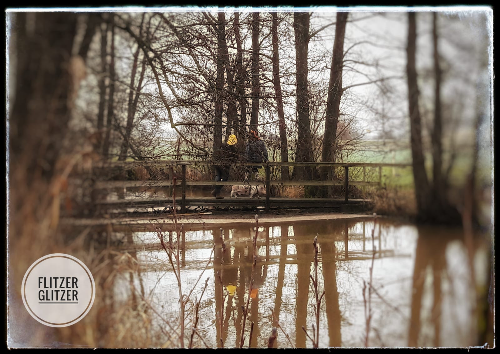Das Hochwasser des kleinen Flusses reicht bis zur Unterkante dieser wunderschönen kleinen Holzbrücke.
